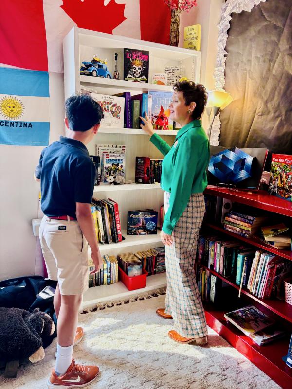 Ms. Caraway showing Kush her classroom library  Kush with Ms. Caraway in her library